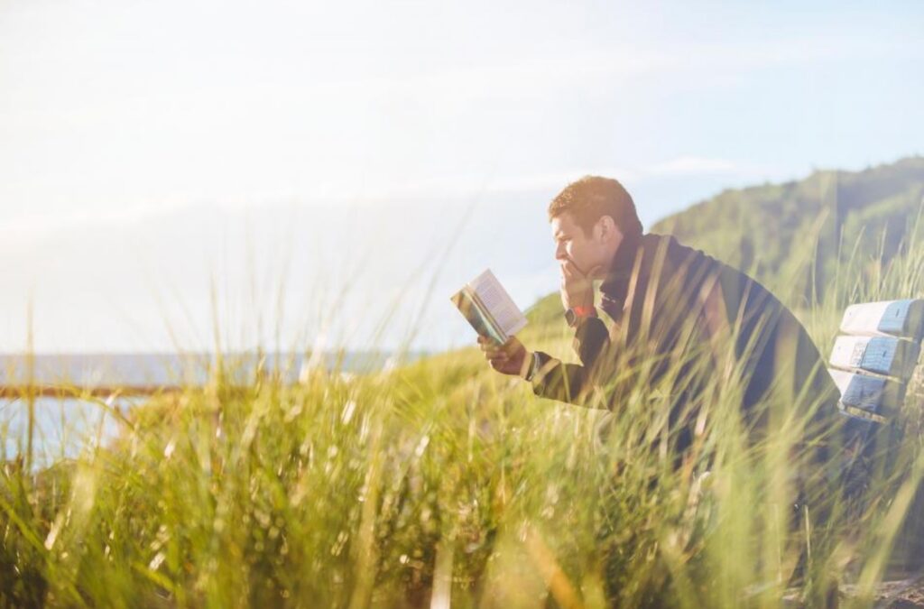 Man reading books about LGBTQ identity in the Christian church.